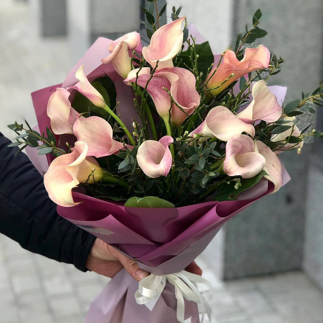 15 нежных калл с зеленью в букете